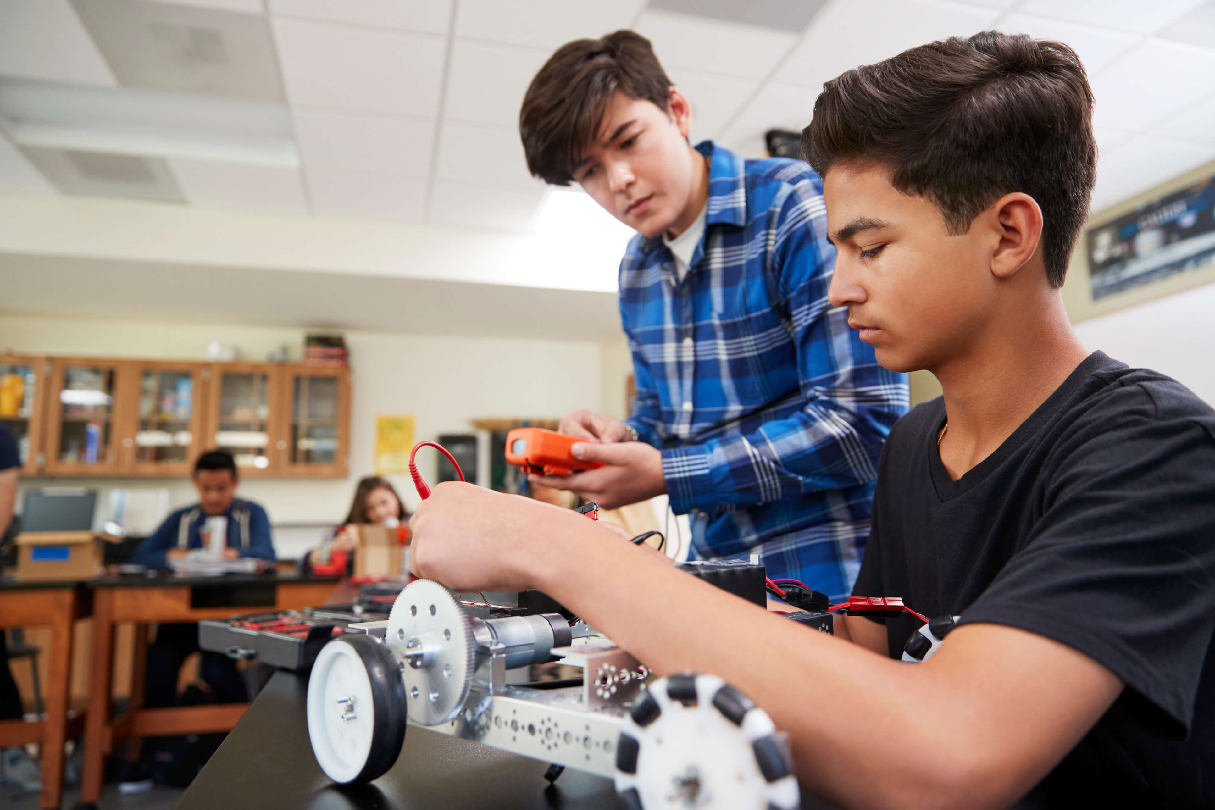 Two male student building a robot.
